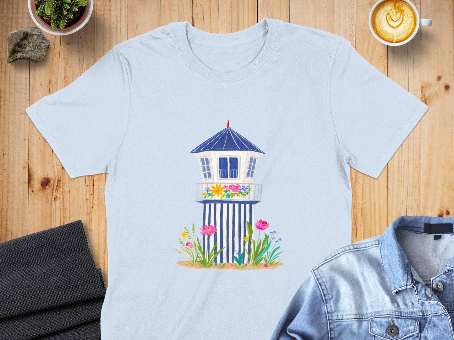 Light blue t-shirt featuring a cartoon lifeguard tower with flowers.