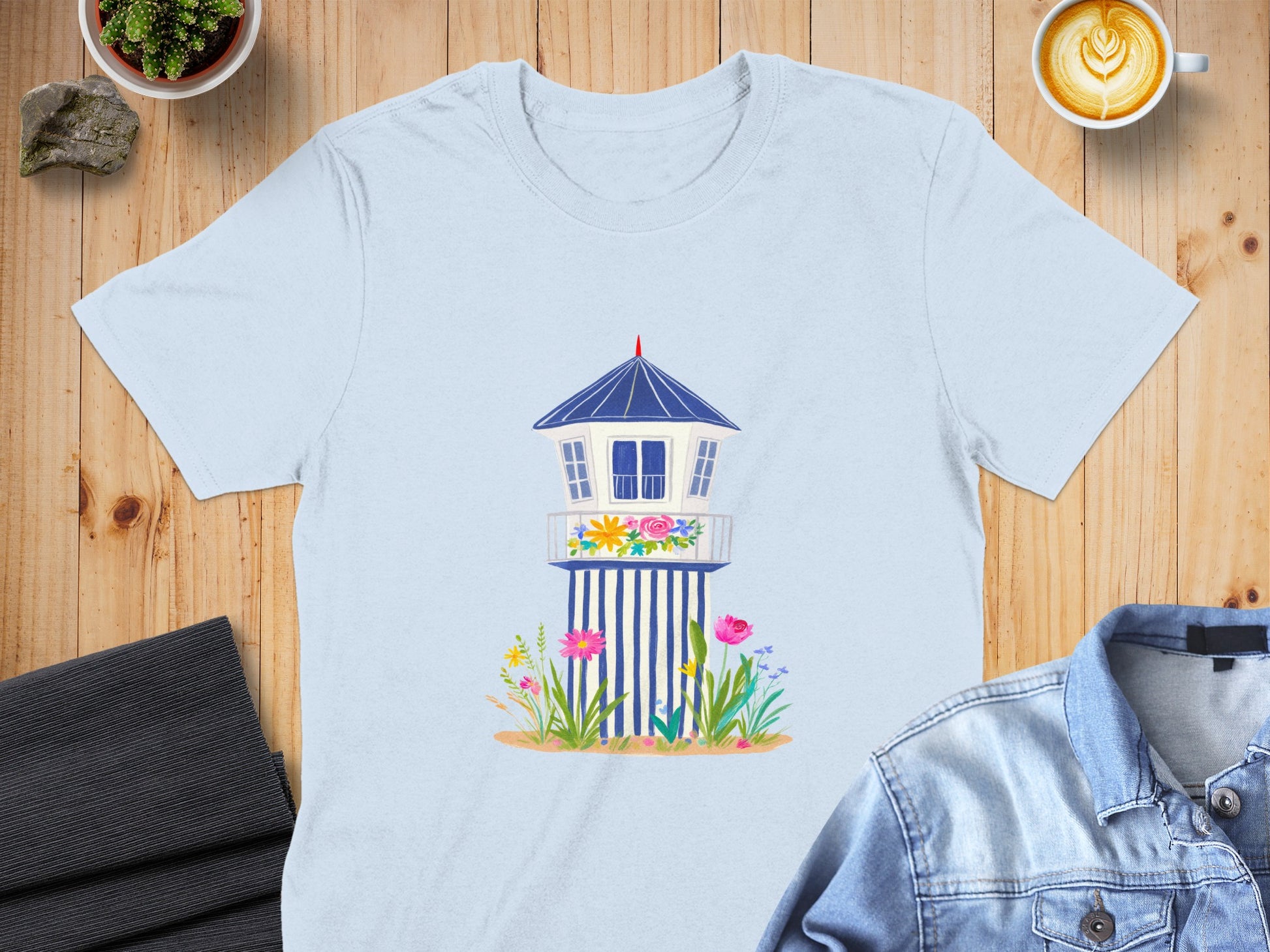 Light blue t-shirt featuring a cartoon lifeguard tower with flowers.