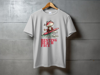 White t-shirt with graphic of frog surfing and text "RESTING BEACH FACE."