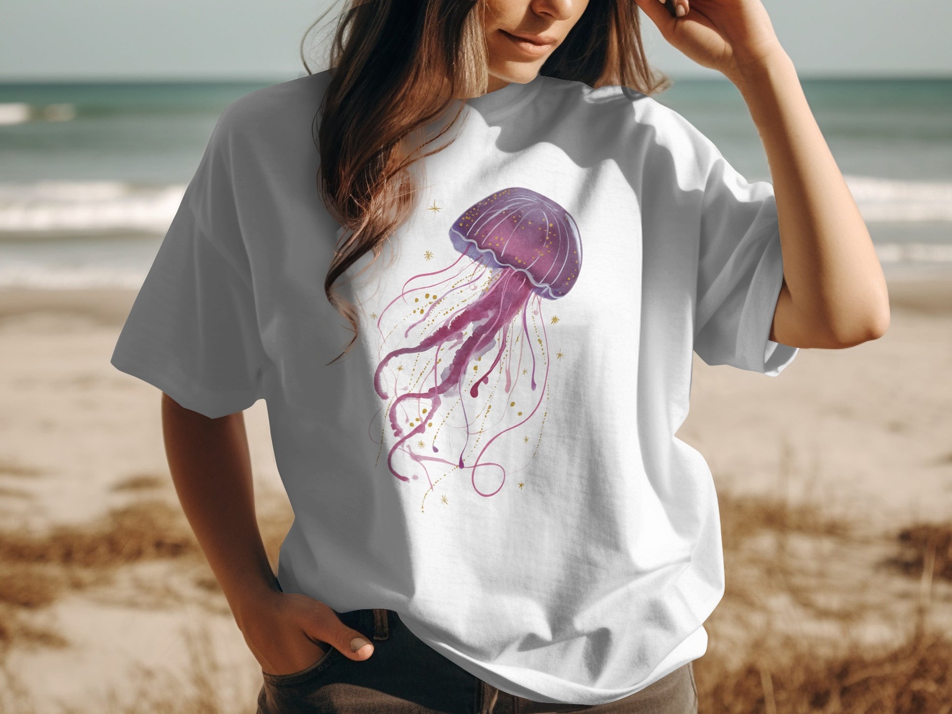 White t-shirt with a purple watercolor jellyfish graphic and gold accents.