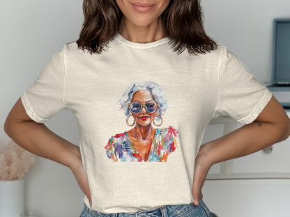 Woman wearing a cream t-shirt with a vibrant watercolor portrait of an older woman.