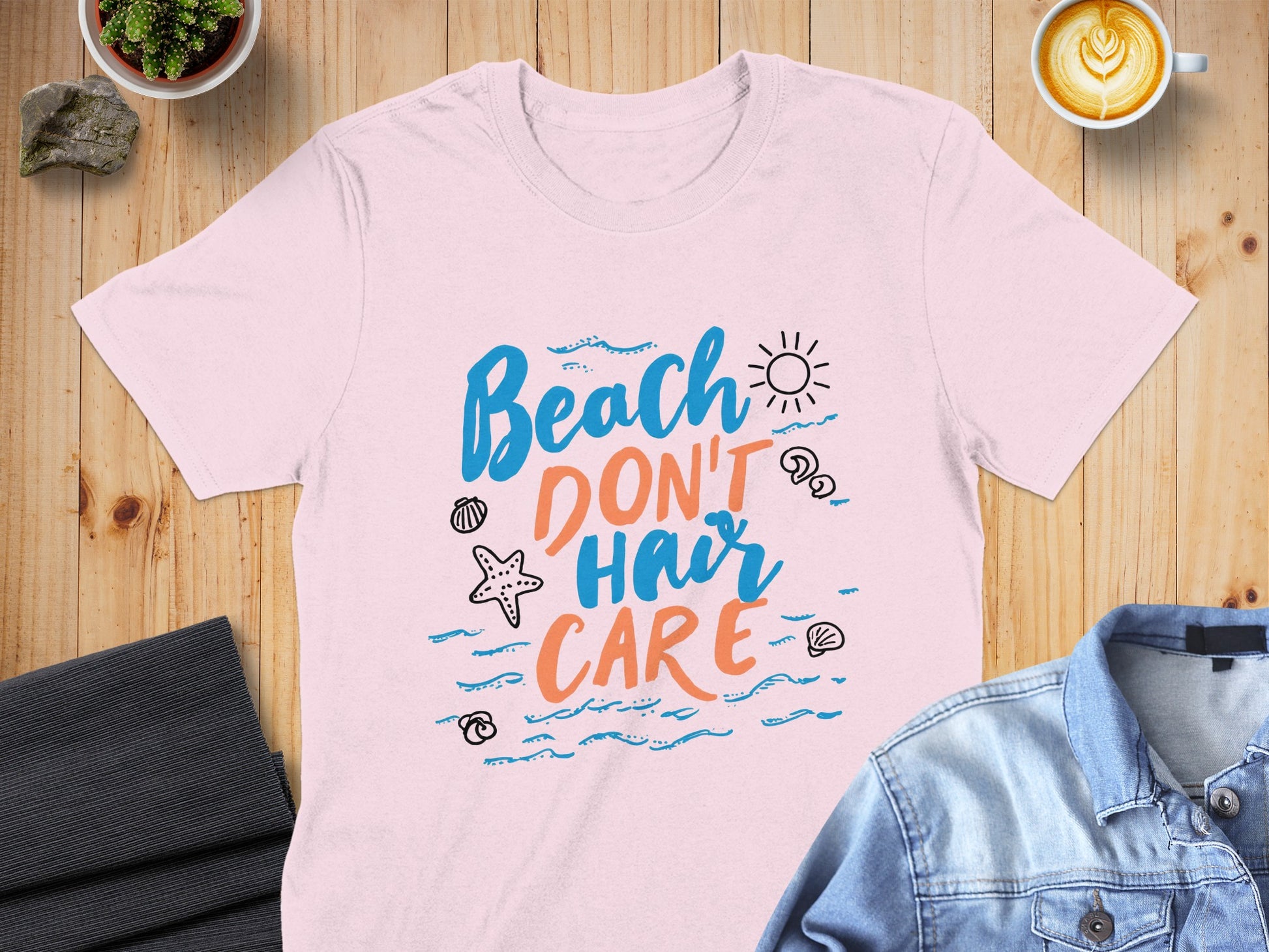 Pink t-shirt with "Beach Don't Hair Care" text and sun and shell graphics.