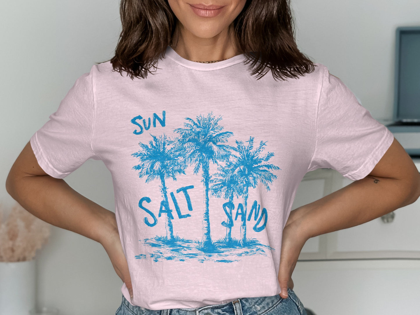Light pink t-shirt with blue palm trees and "SUN SALT SAND" text.