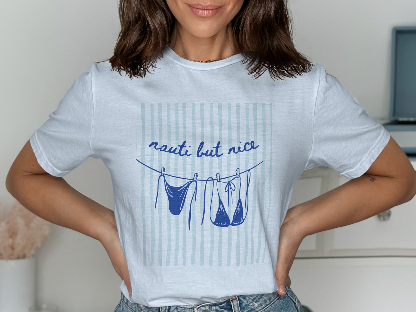 White t-shirt with blue text and bikini line drying on a clothesline.