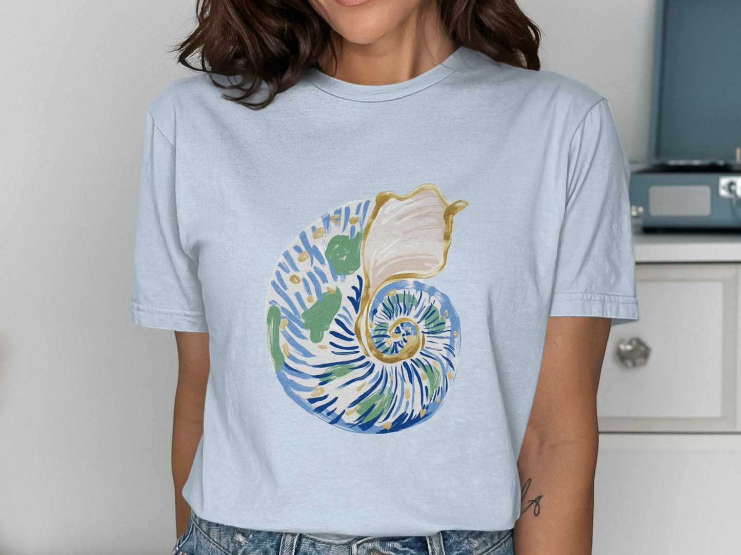 Light blue t-shirt with a watercolor nautilus shell design.