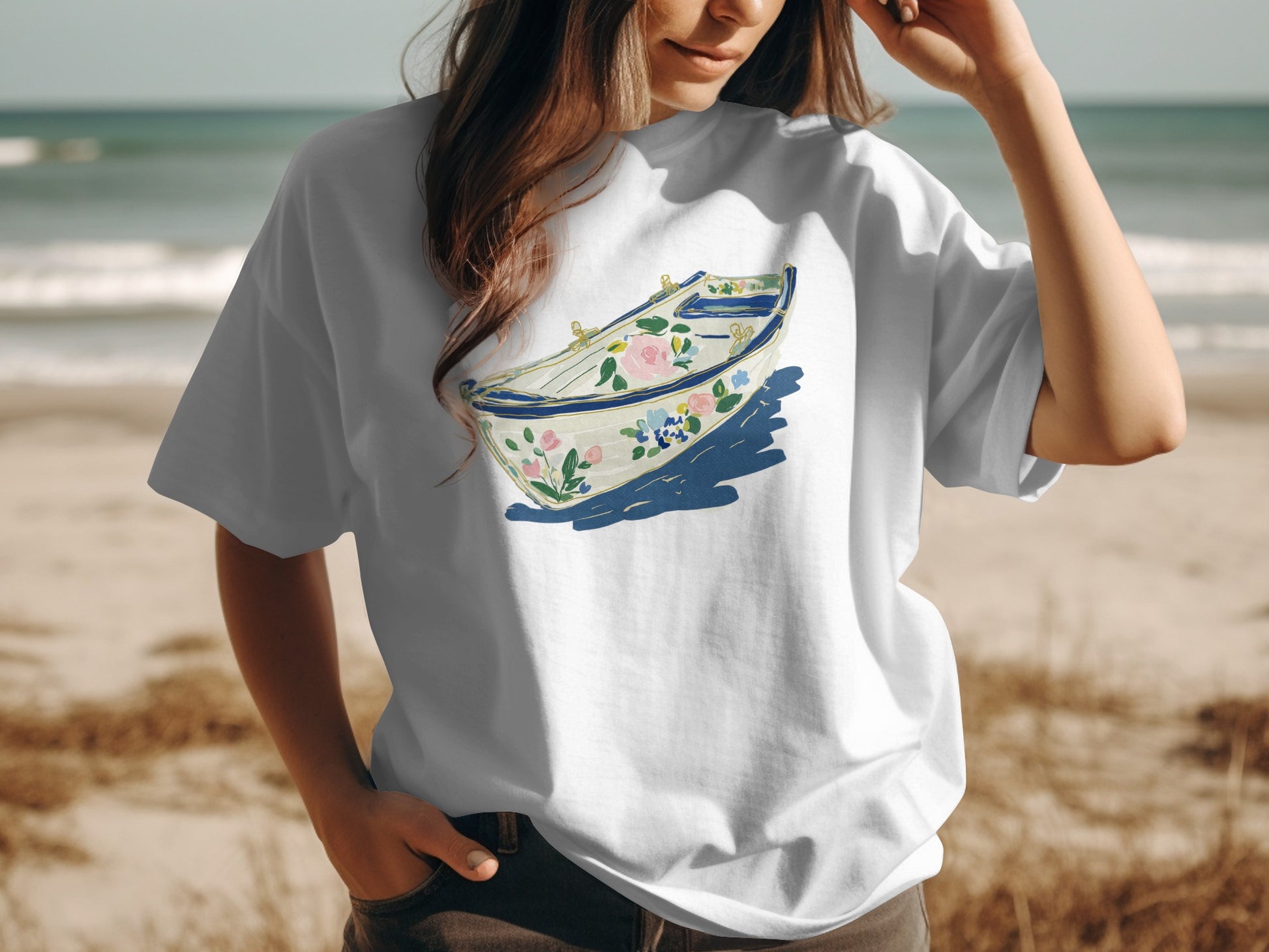 Woman wearing white t-shirt with blue and pink floral boat illustration.