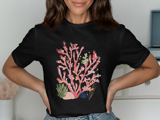 Black t-shirt with a watercolor illustration of pink coral and green accents.