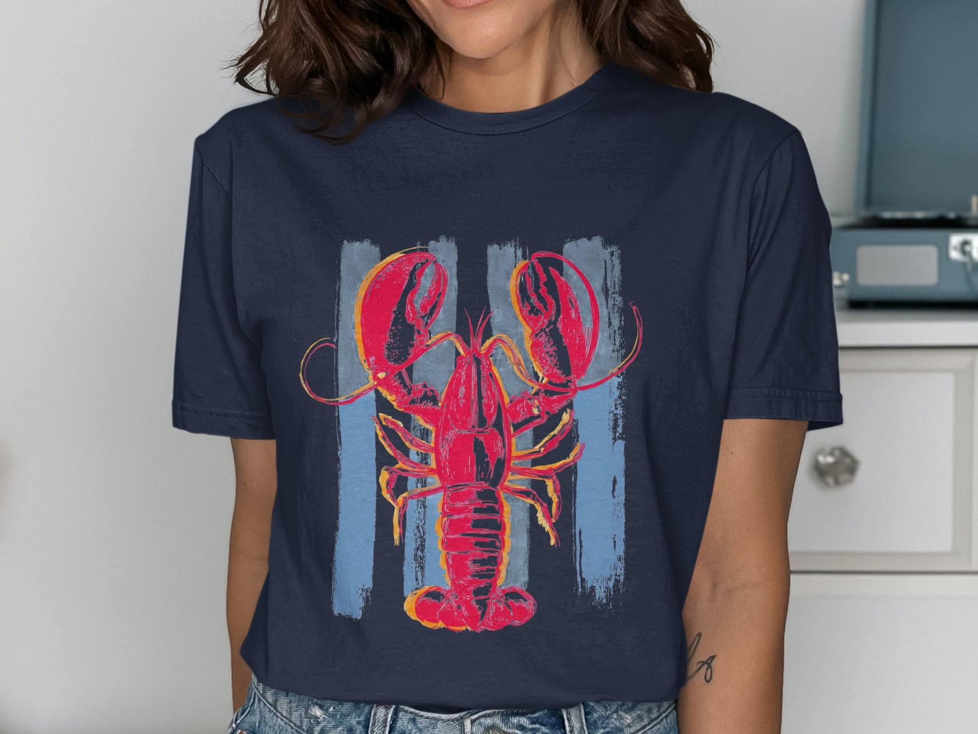 Navy t-shirt featuring a stylized red lobster graphic on a muted blue striped background.
