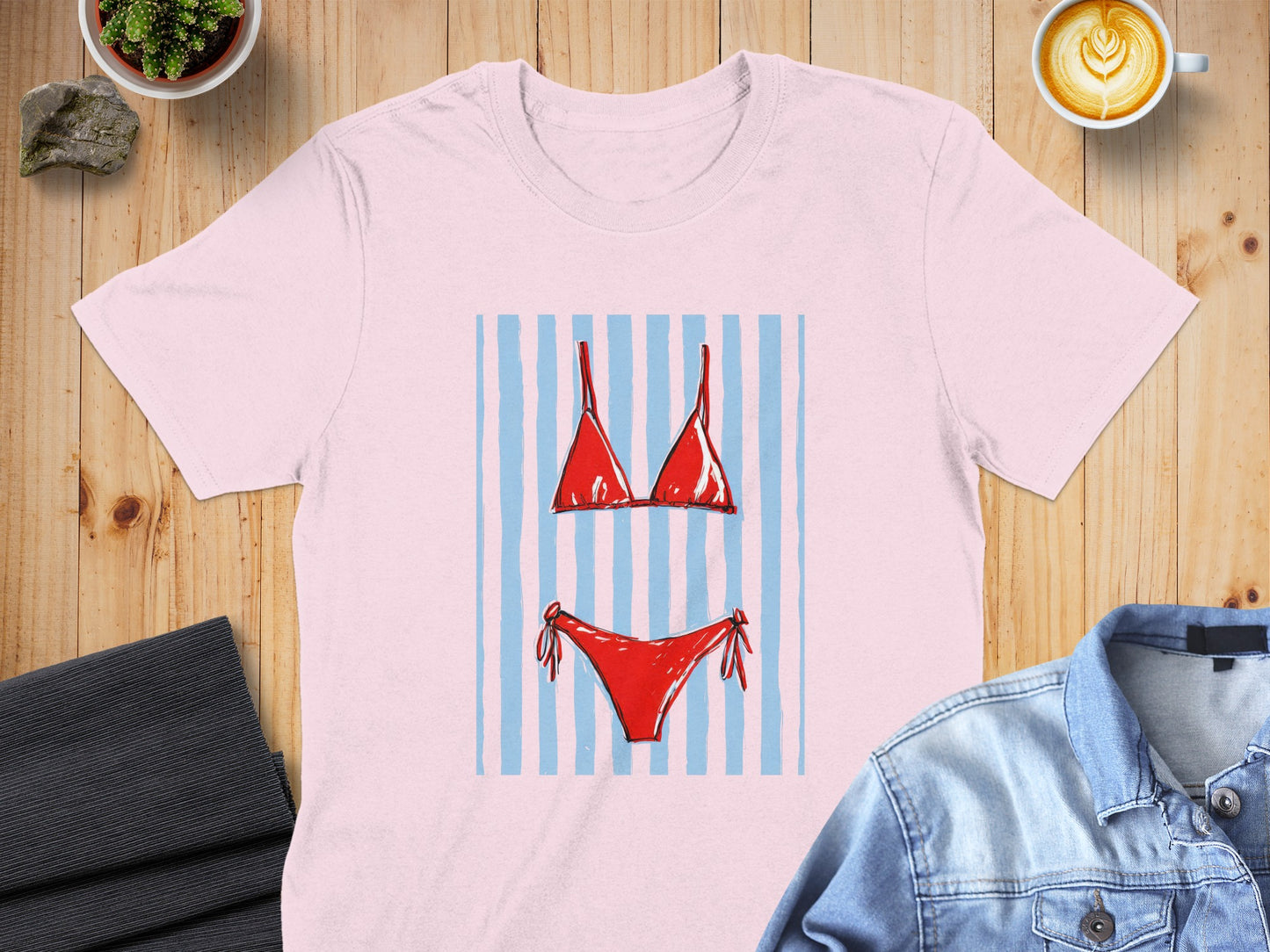 Pink t-shirt featuring a red bikini with blue stripes graphic.