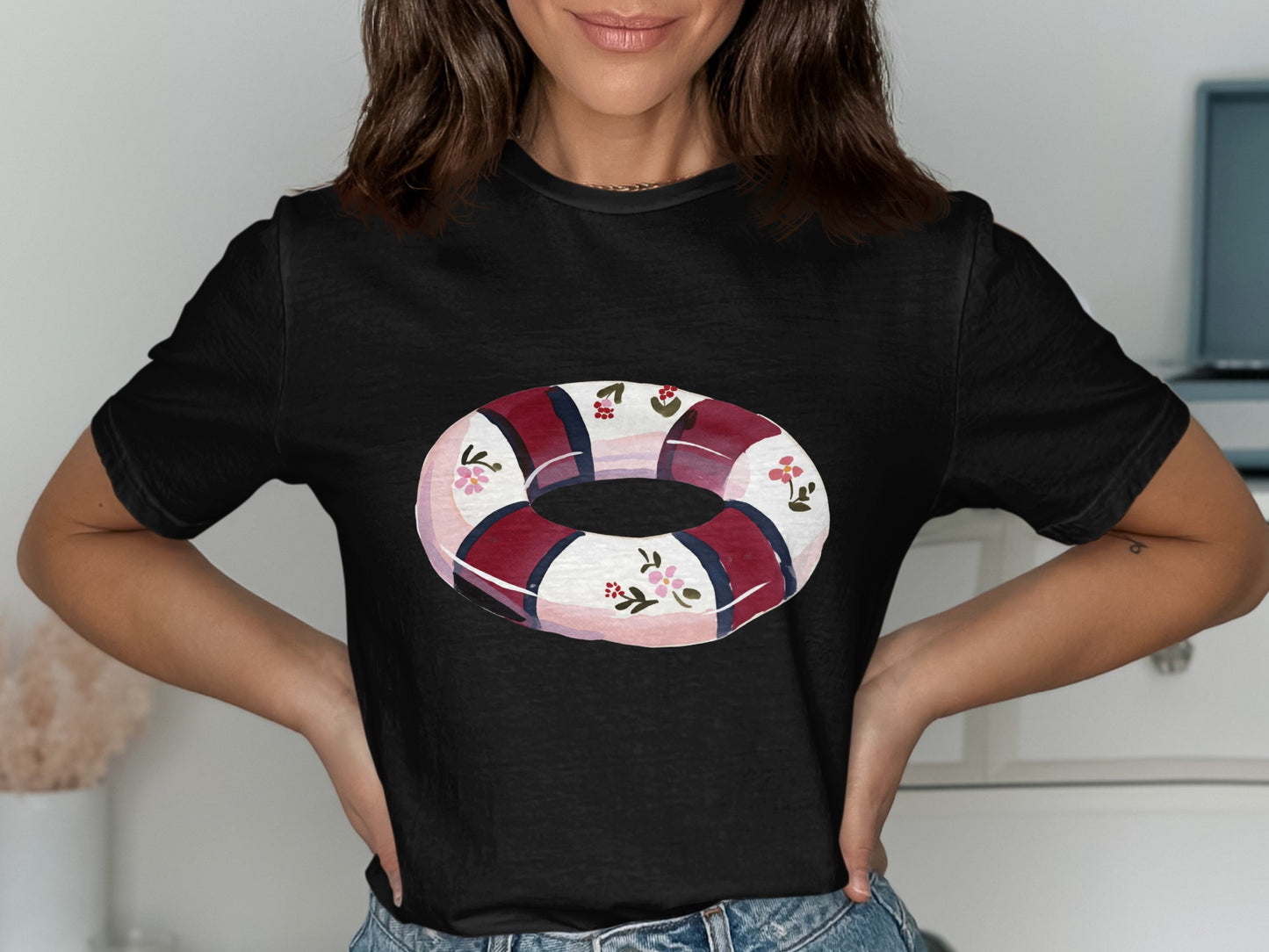 Black t-shirt with a white, red, and blue floral life preserver graphic.