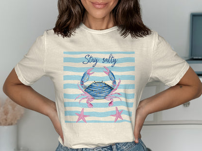Cream t-shirt with blue stripes and a crab and starfish graphic that says "Stay Salty".