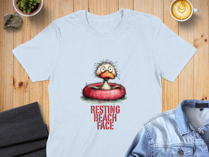 Light blue t-shirt featuring a cartoon duck in an inner tube with "RESTING BEACH FACE" text.