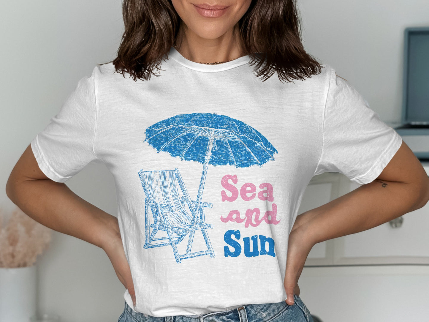 White t-shirt with blue beach chair, umbrella, and "Sea and Sun" text.