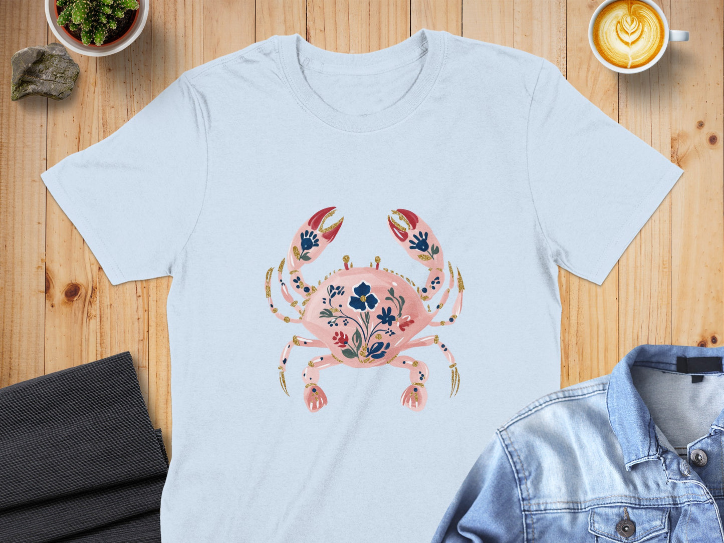 Light blue t-shirt with a pink crab graphic and floral embellishments.