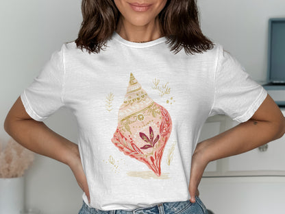 White t-shirt with a detailed illustration of a pink and gold seashell.