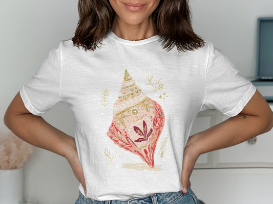 White t-shirt with a detailed illustration of a pink and gold seashell.
