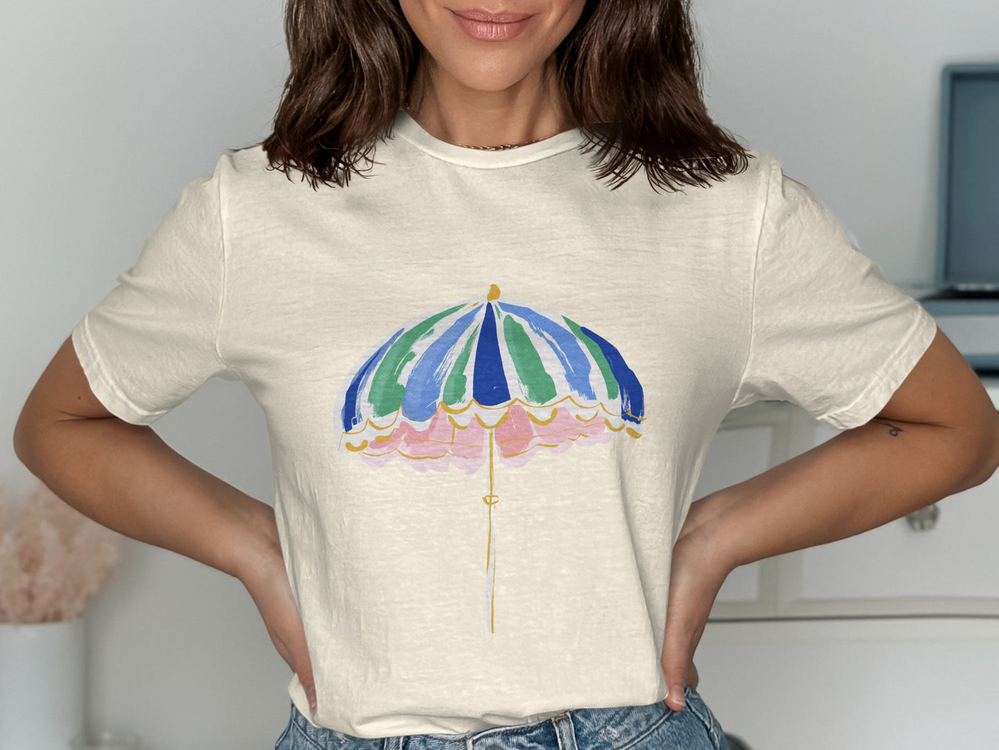 Cream t-shirt with a watercolor-style beach umbrella graphic.