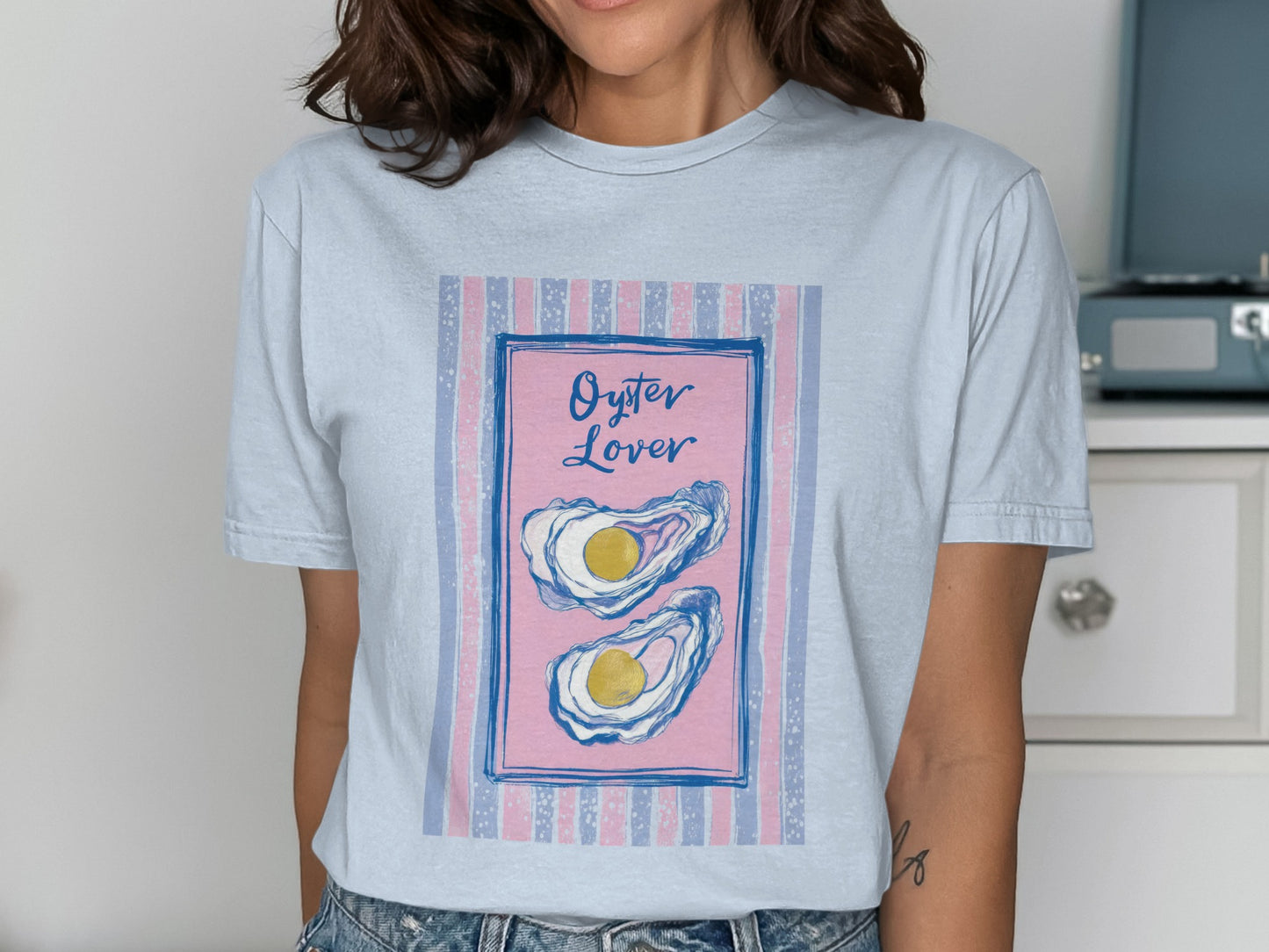 Light blue t-shirt with pink and blue striped background and "Oyster Lover" text.
