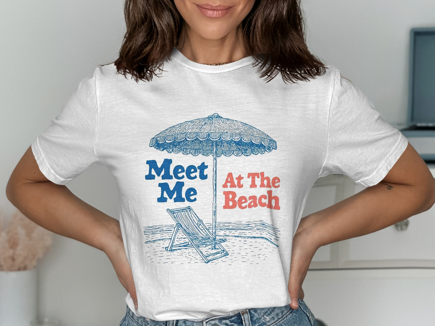 White t-shirt with a blue sketch of a beach umbrella and lounge chair.
