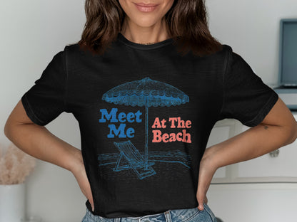 Black t-shirt with "Meet Me At The Beach" text, umbrella, and lounge chair graphic.