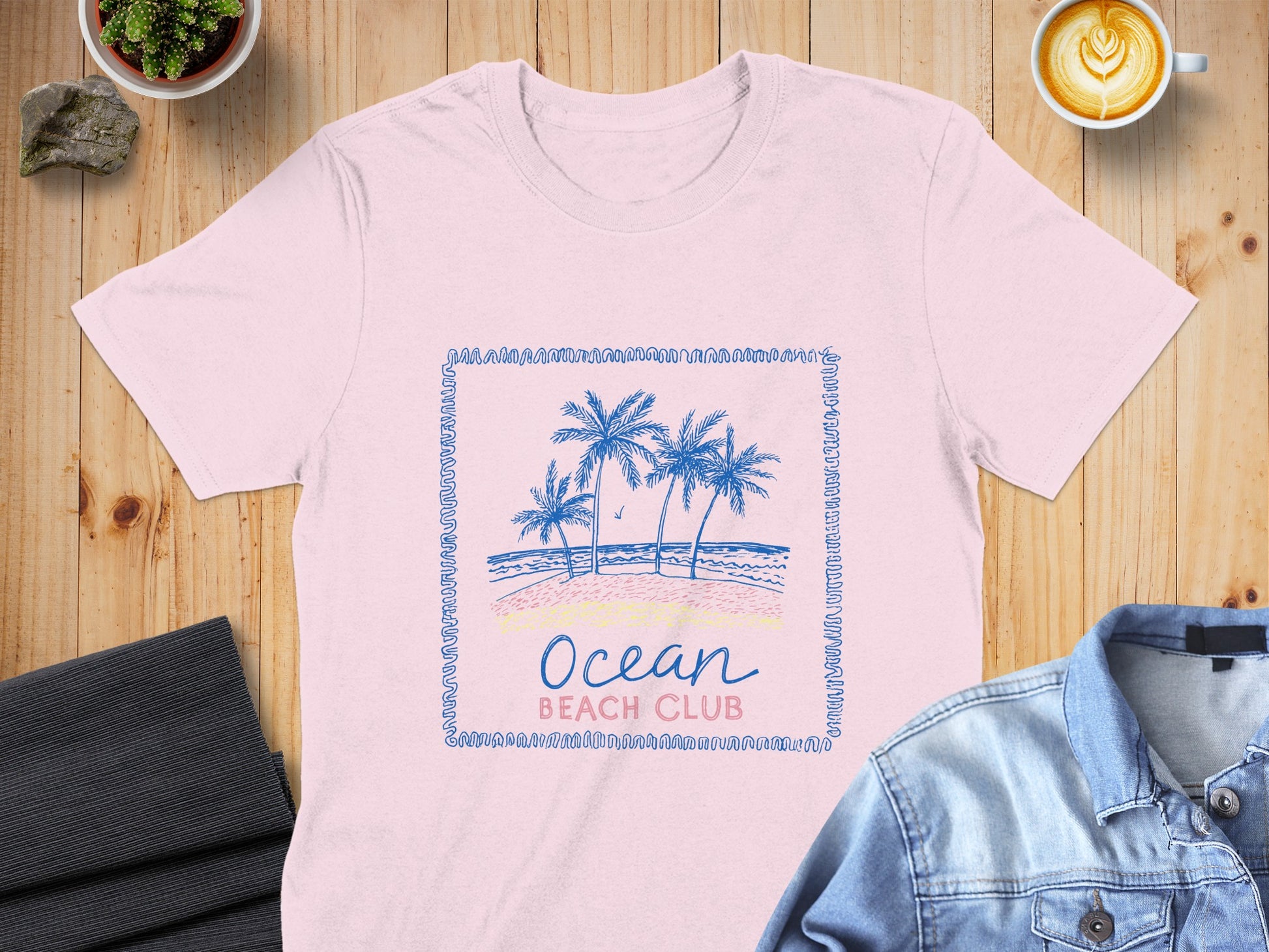 Pink t-shirt with blue palm trees and "Ocean Beach Club" text.