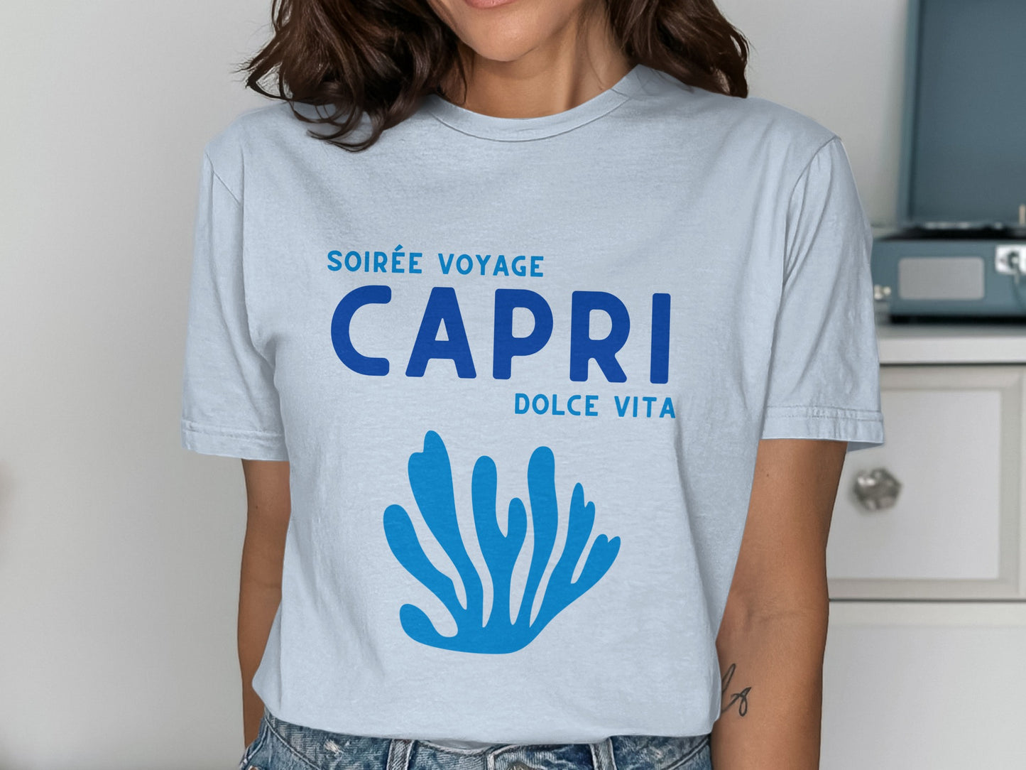 Light blue t-shirt with "SOIRÉE VOYAGE CAPRI DOLCE VITA" and blue coral graphic.