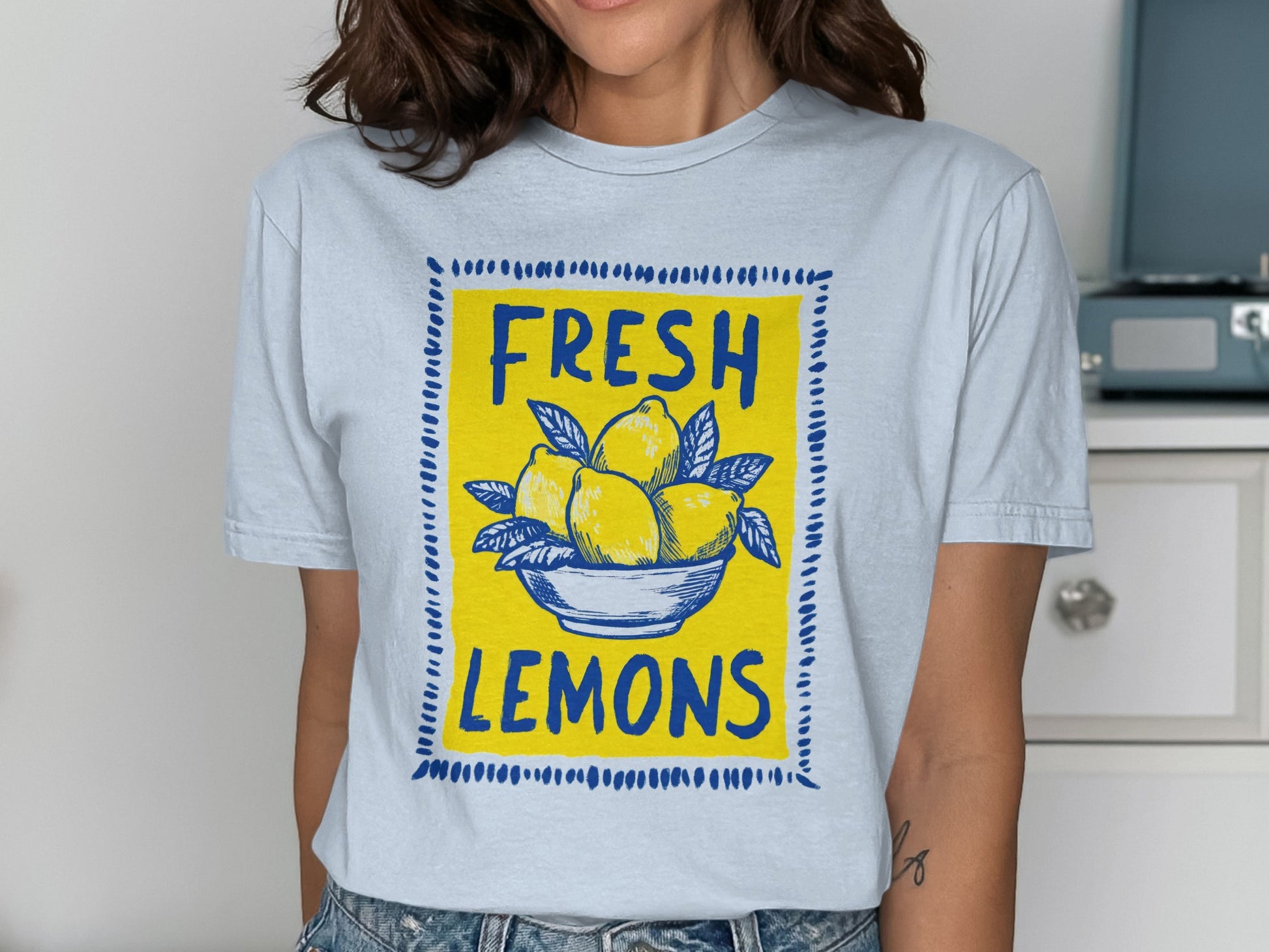 Light blue t-shirt featuring a graphic of lemons in a bowl with "FRESH LEMONS" text.