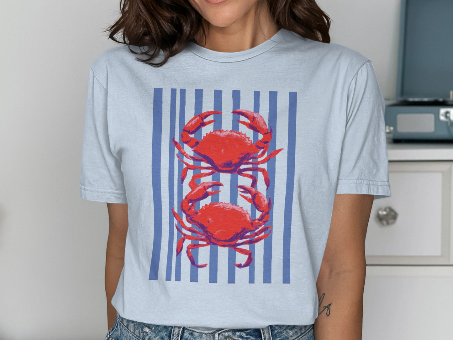 Light blue t-shirt with two red crabs on blue stripes.
