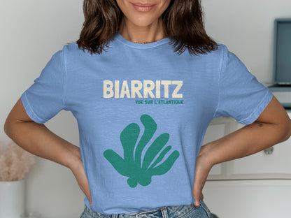 Light blue t-shirt with "BIARRITZ" and "VUE SUR L'ATLANTIQUE" text and green abstract shape.