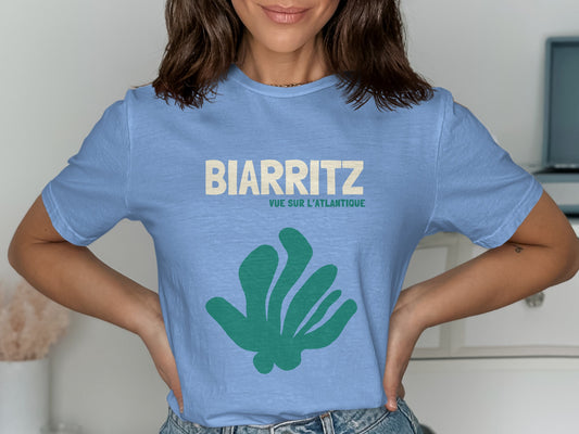 Light blue t-shirt with "BIARRITZ" and "VUE SUR L'ATLANTIQUE" text and green abstract shape.