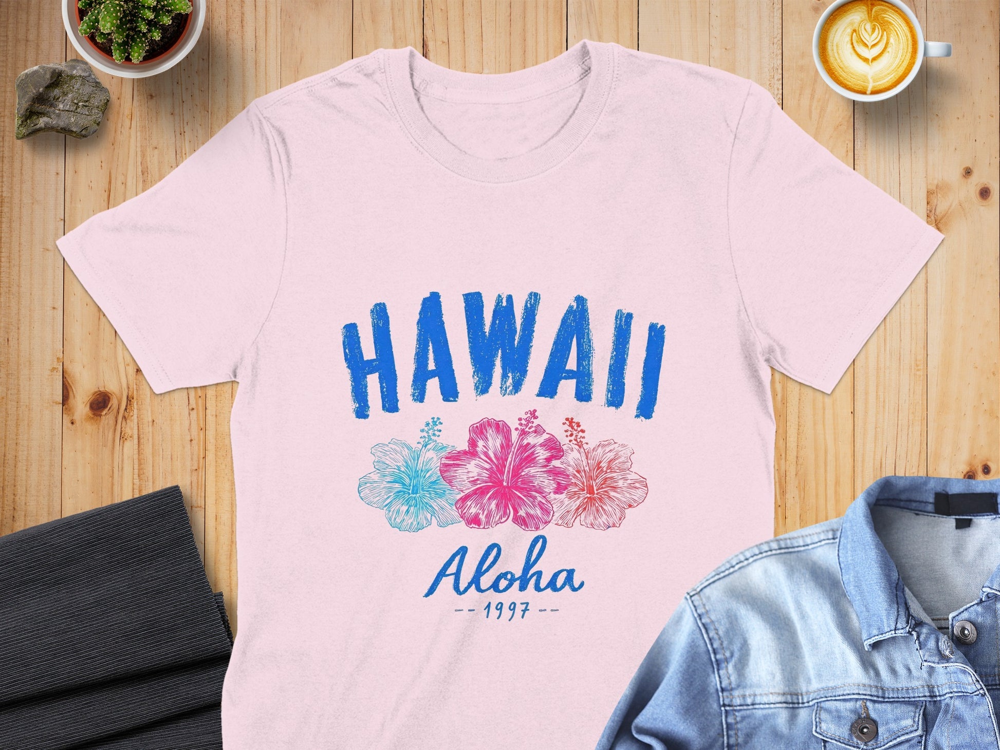 Pink t-shirt with "HAWAII Aloha - 1997" text and hibiscus flowers.
