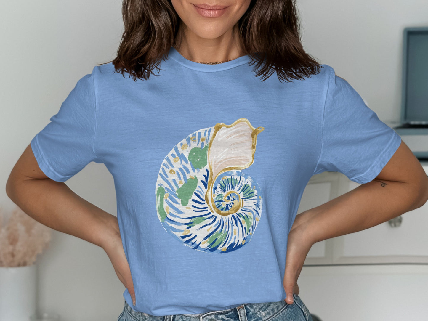Light blue t-shirt with a watercolor nautilus shell graphic.