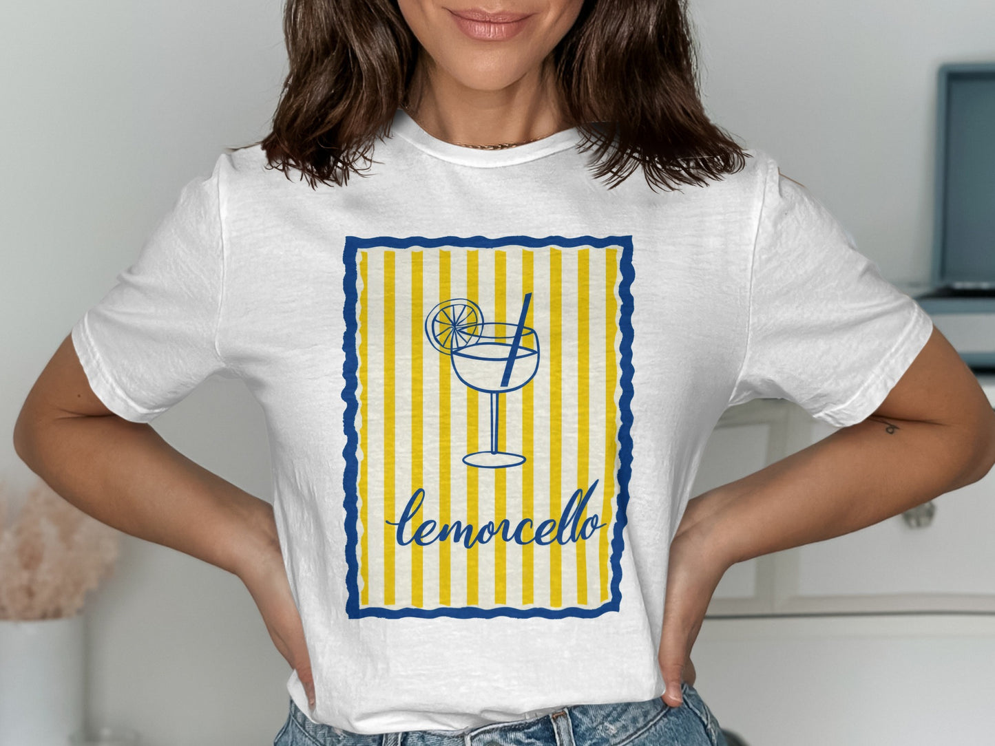 White t-shirt with yellow and blue striped border and limoncello graphic.