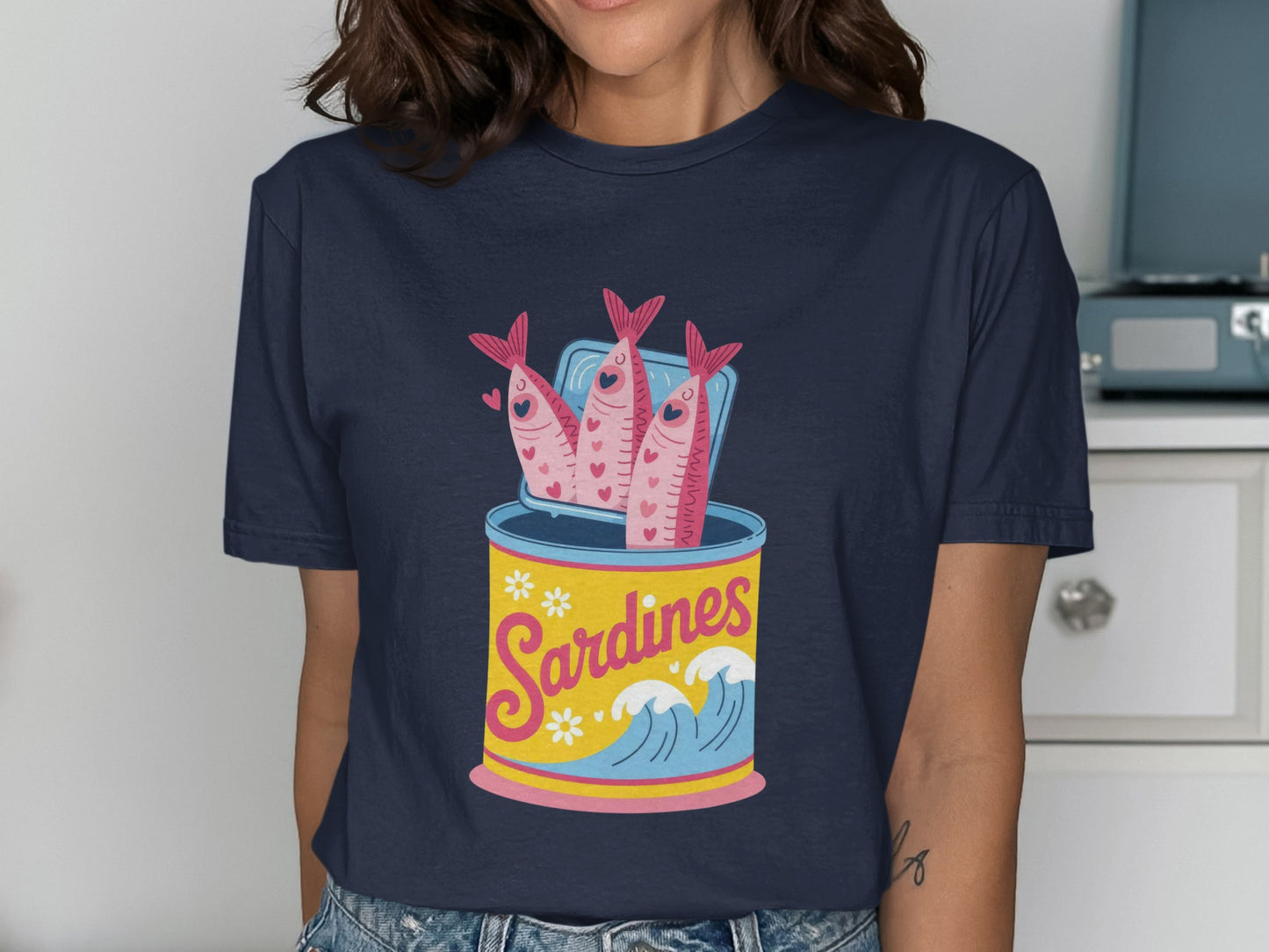 T-shirt with cartoon sardines in an open can with waves and flowers.