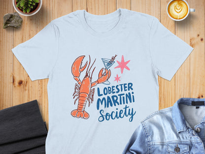 Lobster Martini Society logo with lobster and martini glass on a light blue t-shirt.