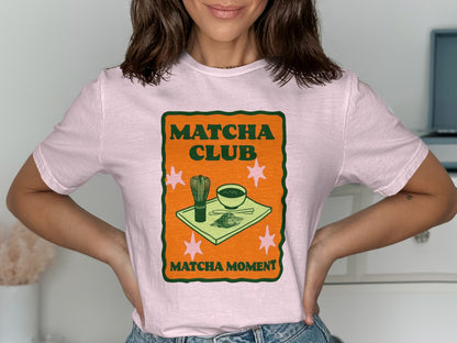 Pink t-shirt with "Matcha Club Matcha Moment" text and matcha whisk and bowl graphic.