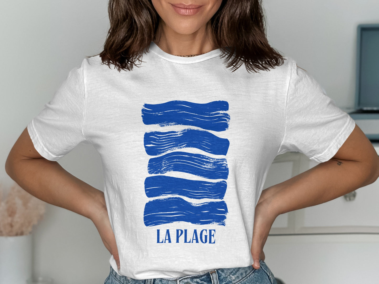 White t-shirt with blue wavy stripes and "LA PLAGE" text.