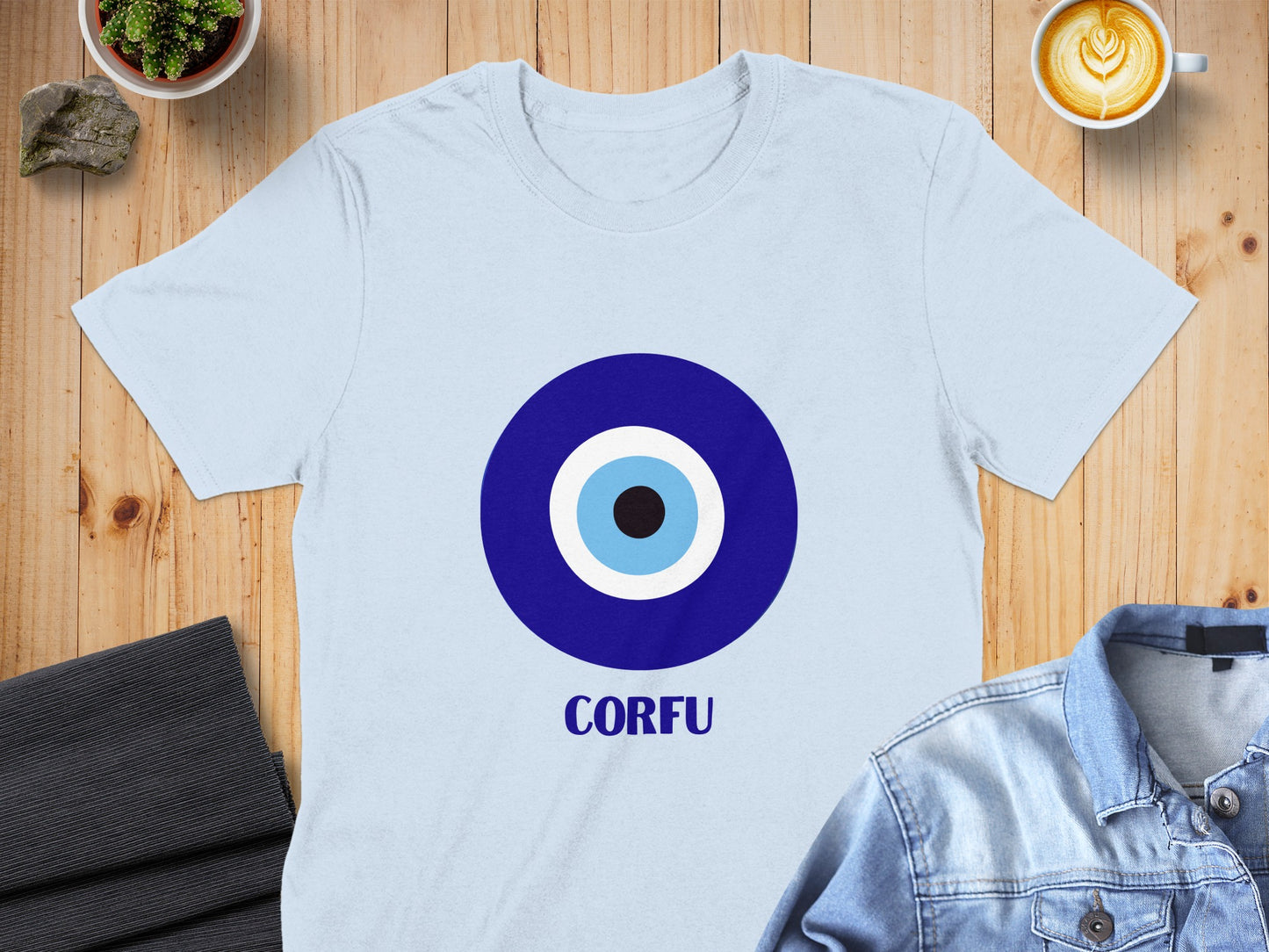 Light blue t-shirt with a blue and white evil eye symbol and "CORFU" text.