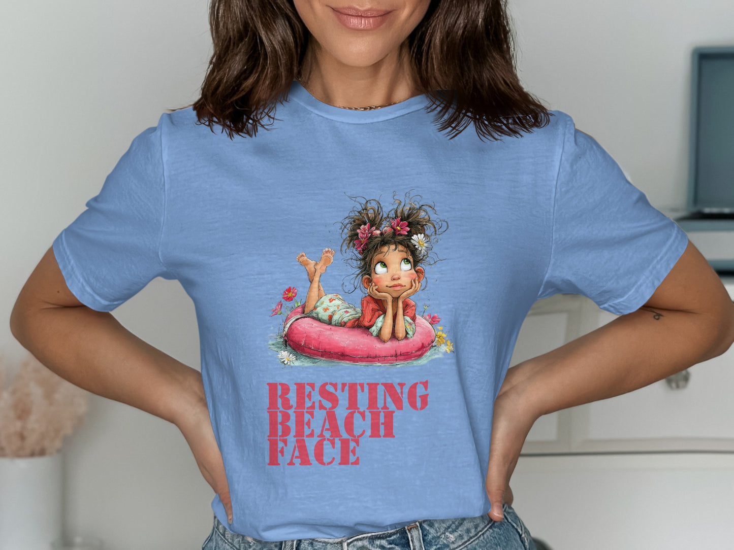 T-shirt with graphic of girl relaxing on inflatable ring, reads "RESTING BEACH FACE".