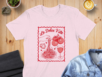 Pink t-shirt with "La Dolce Vita" text and pasta, tomatoes, garlic, and wine illustration.