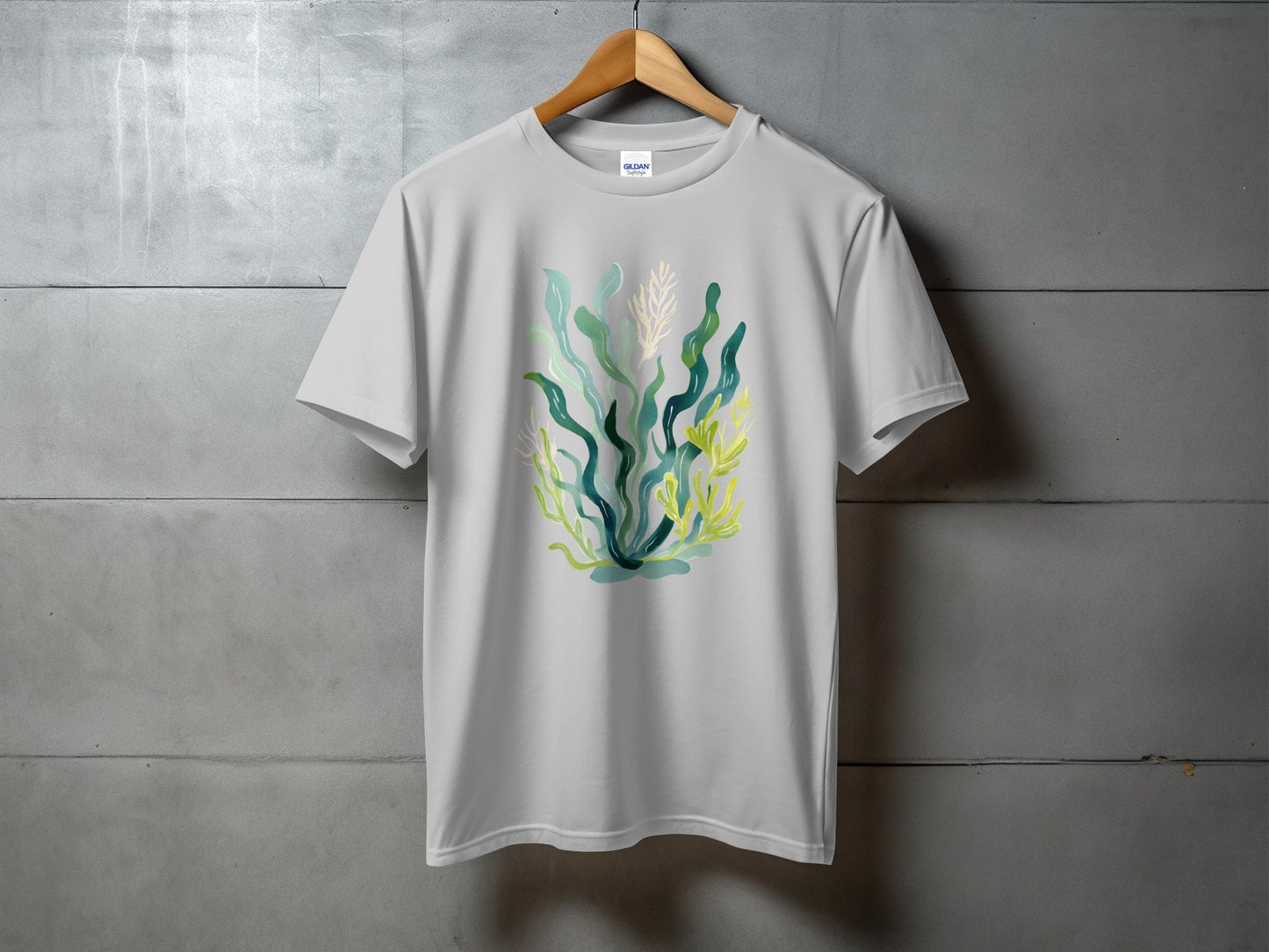 White t-shirt with watercolor illustration of green and yellow seaweed.
