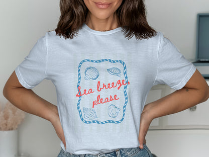 White t-shirt with "Sea breeze please" and seashell graphic.
