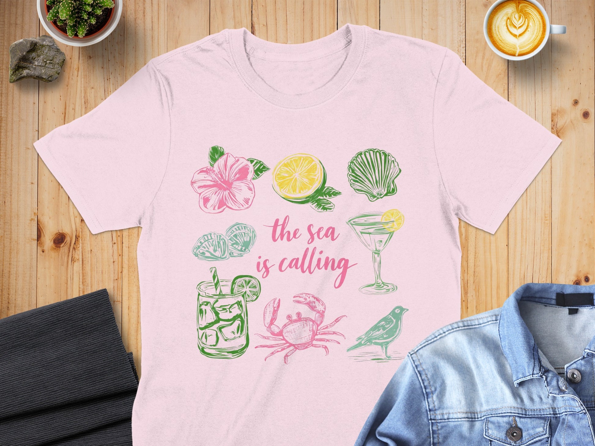 Pink t-shirt with hand-drawn sea-themed illustrations and text.