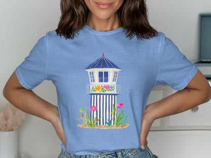 Light blue t-shirt featuring a cartoon lifeguard tower surrounded by flowers.