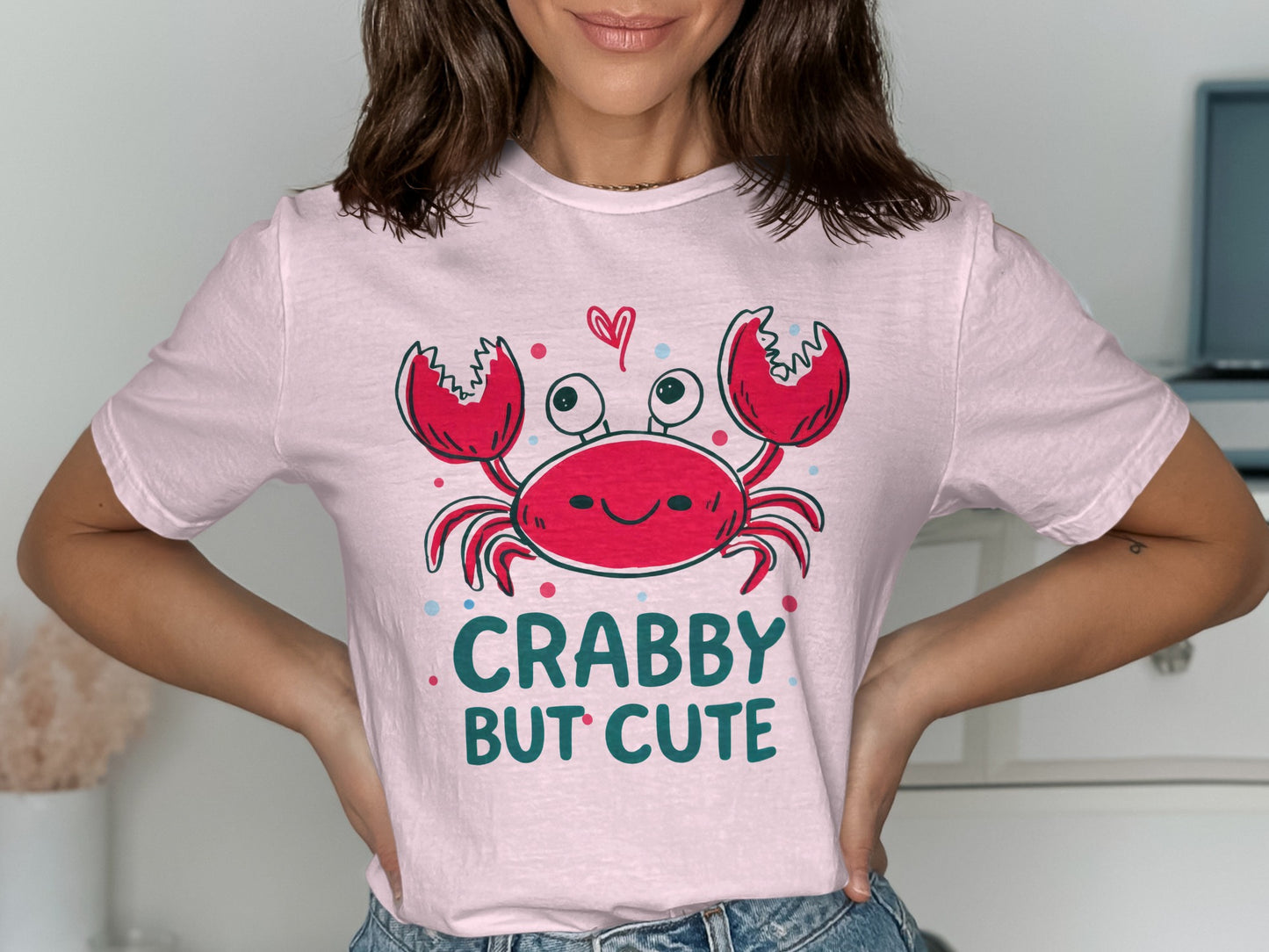 Pink t-shirt with a smiling crab and text "Crabby But Cute".