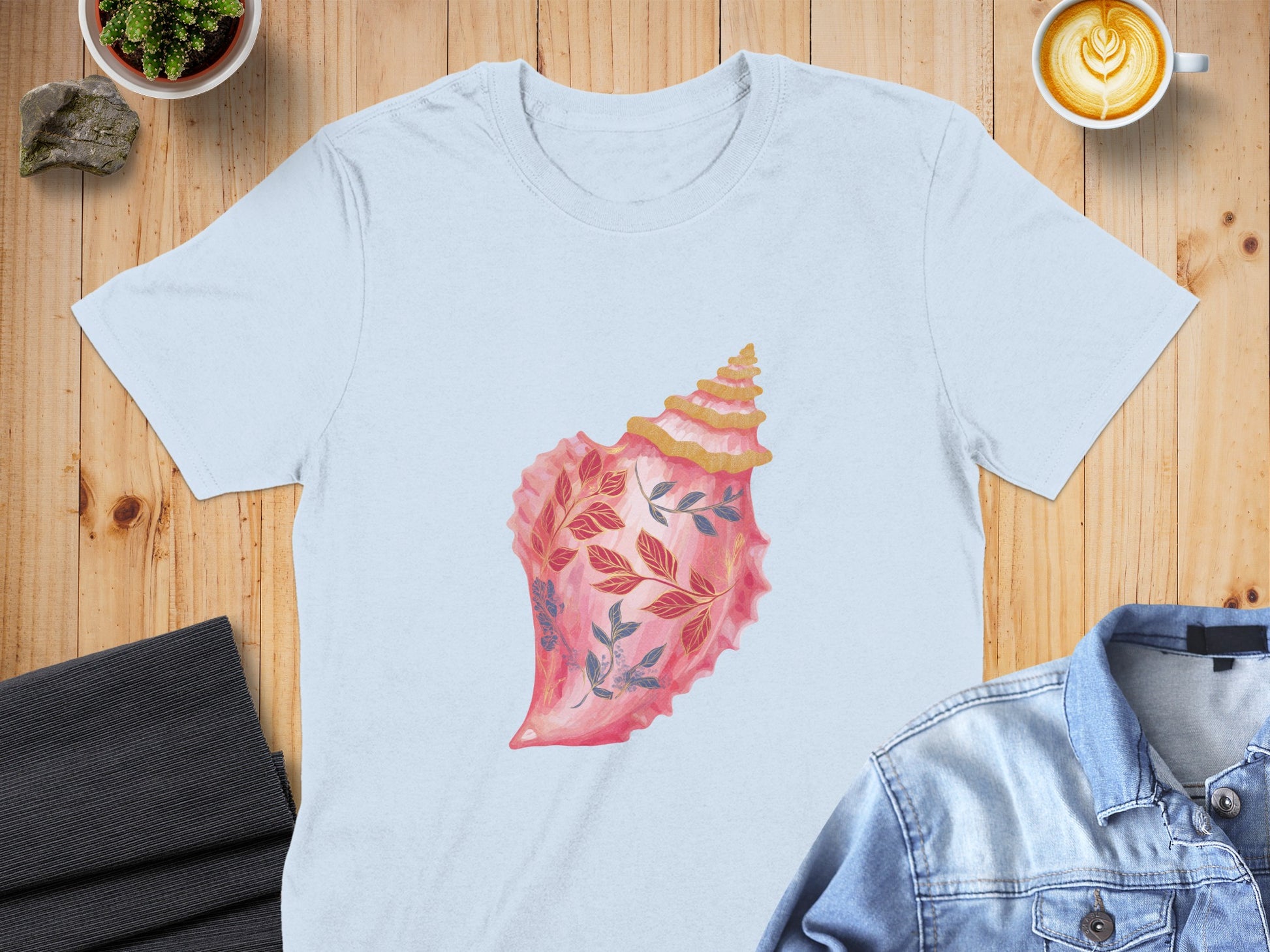 Light blue t-shirt with a pink conch shell design featuring blue and red foliage.