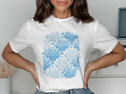 White t-shirt with a repeating pattern of blue seashell graphics.