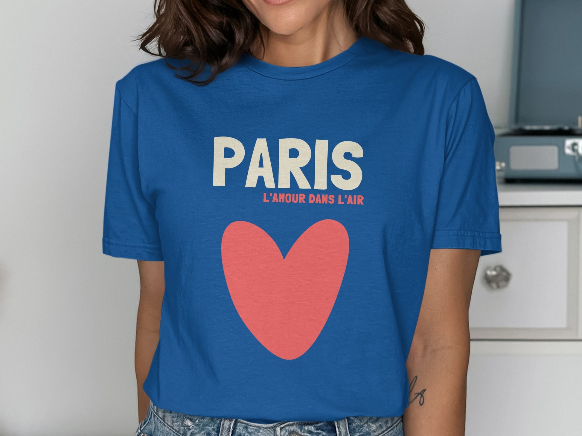 Blue t-shirt with "PARIS L'AMOUR DANS L'AIR" text and a large red heart.