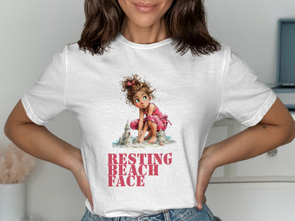 White t-shirt with illustration of a girl building sandcastles with text "RESTING BEACH FACE".