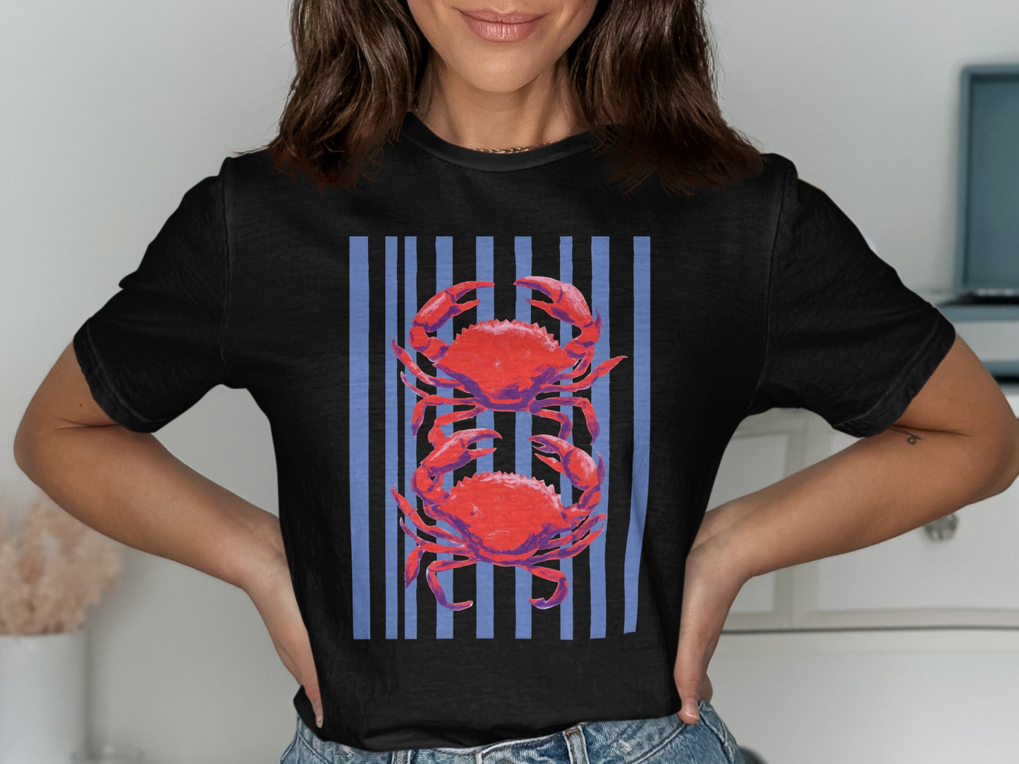 Black t-shirt with two red crabs against a blue striped background.